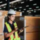 Groupe d'employés vérifiant les détails du produit avec une tablette dans un entrepôt